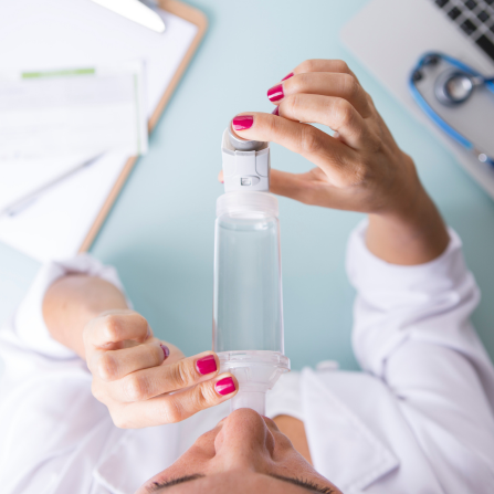 Une femme médecin montre et utilise une chambre d'inhalation