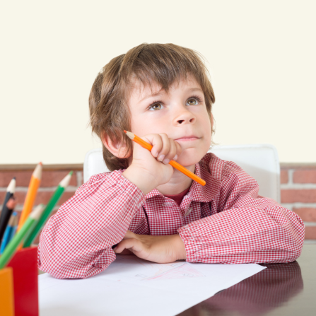 Un enfant sur une table d'école semble manquer de concentration