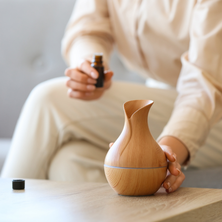 Une femme ajoute des huiles essentielles dans un diffuseur