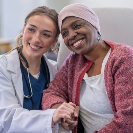 Une femme souriante se bat contre le cancer auprès d'une équipe spécialisée