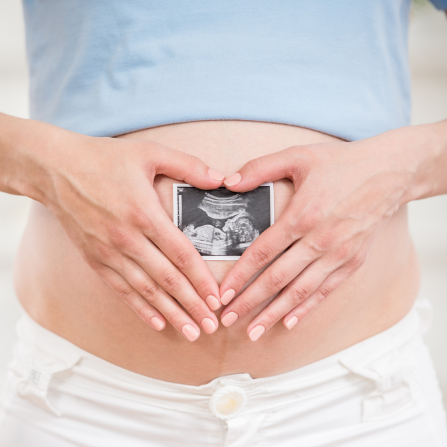 Une femme enceinte tient une échographie sur son ventre 