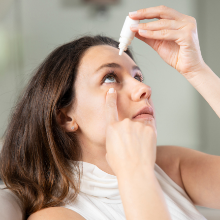 Une femme se met des gouttes dans les yeux