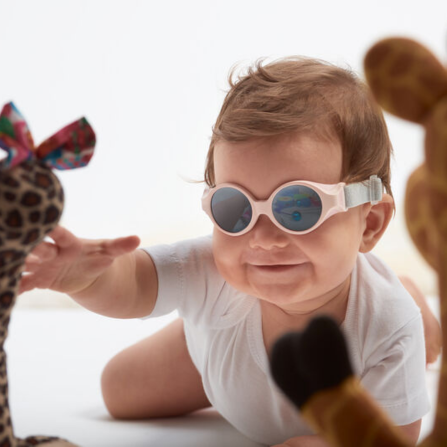 Un bébé porte des lunettes de soleil Beaba