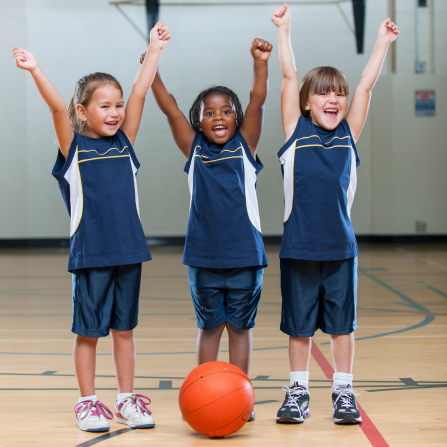 Trois petites filles heureuses de faire du basket ensemble